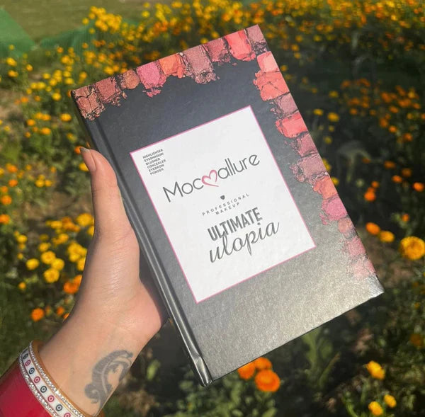Book titled 'Ultimate Utopia' by Moccaallure held in front of a floral background