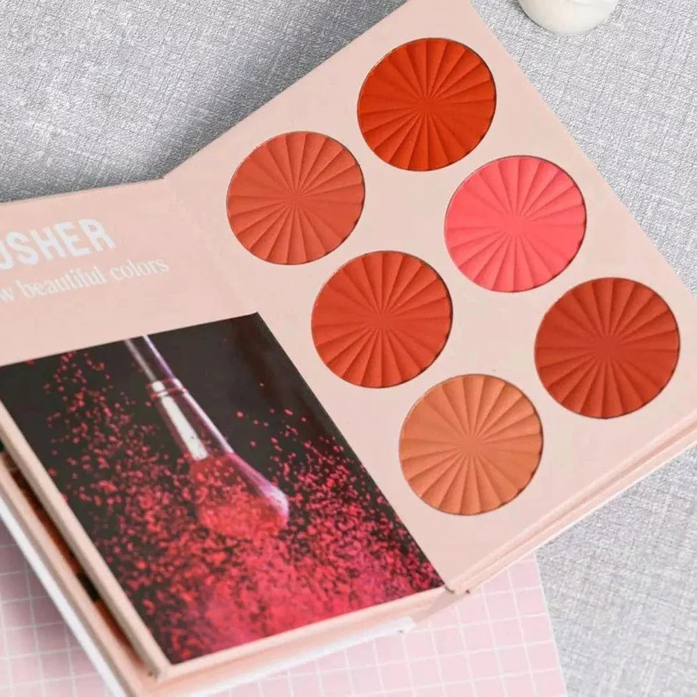 Makeup palette with red and orange shades on a gray surface